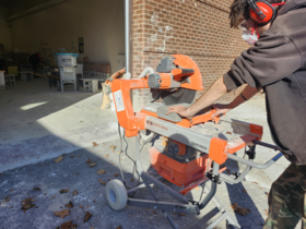 A student is using a machine to cut bricks