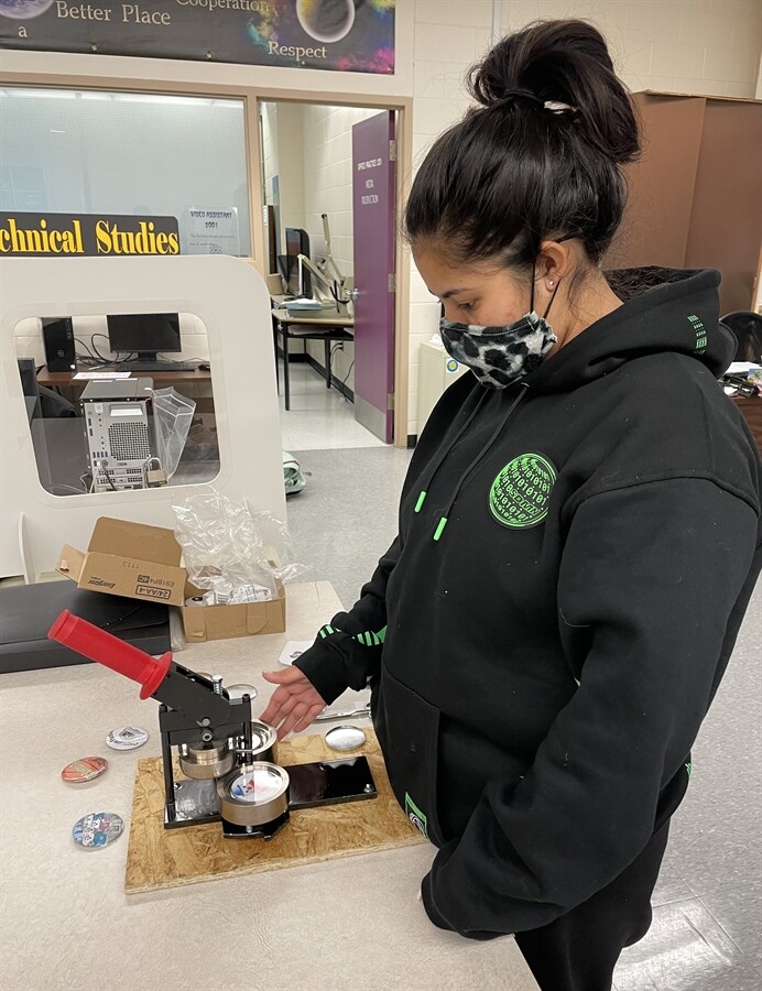 Student using a button maker