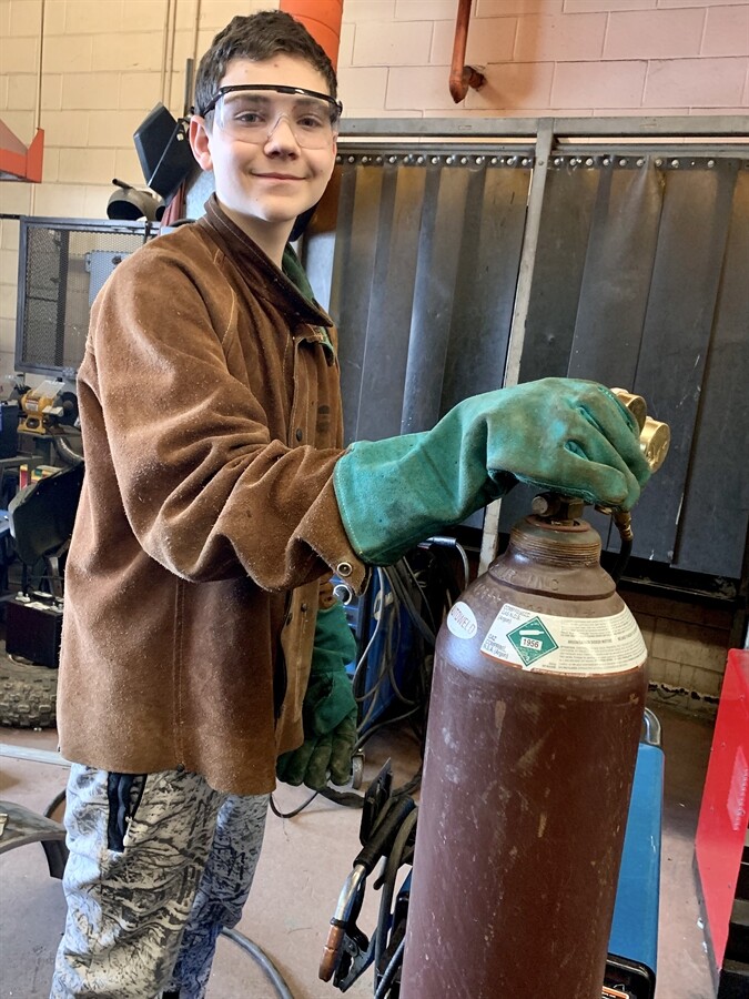 picture of a student holding the top of an oxygen tank