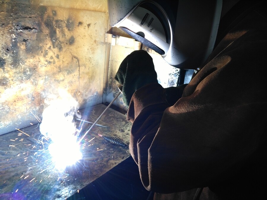 Picture of a student welding a piece of metal