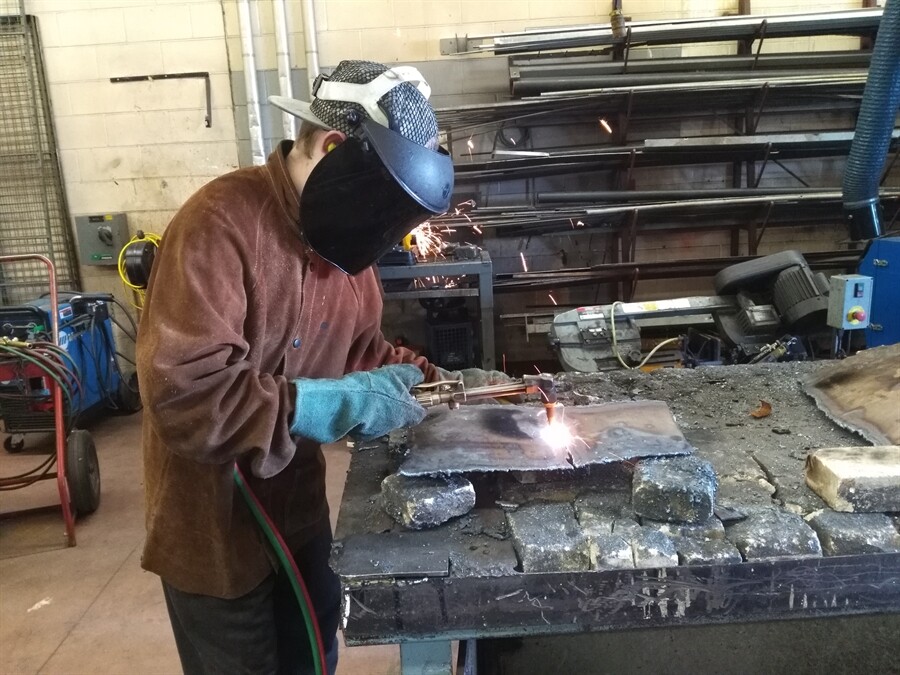 Picture of a student welding a piece of metal