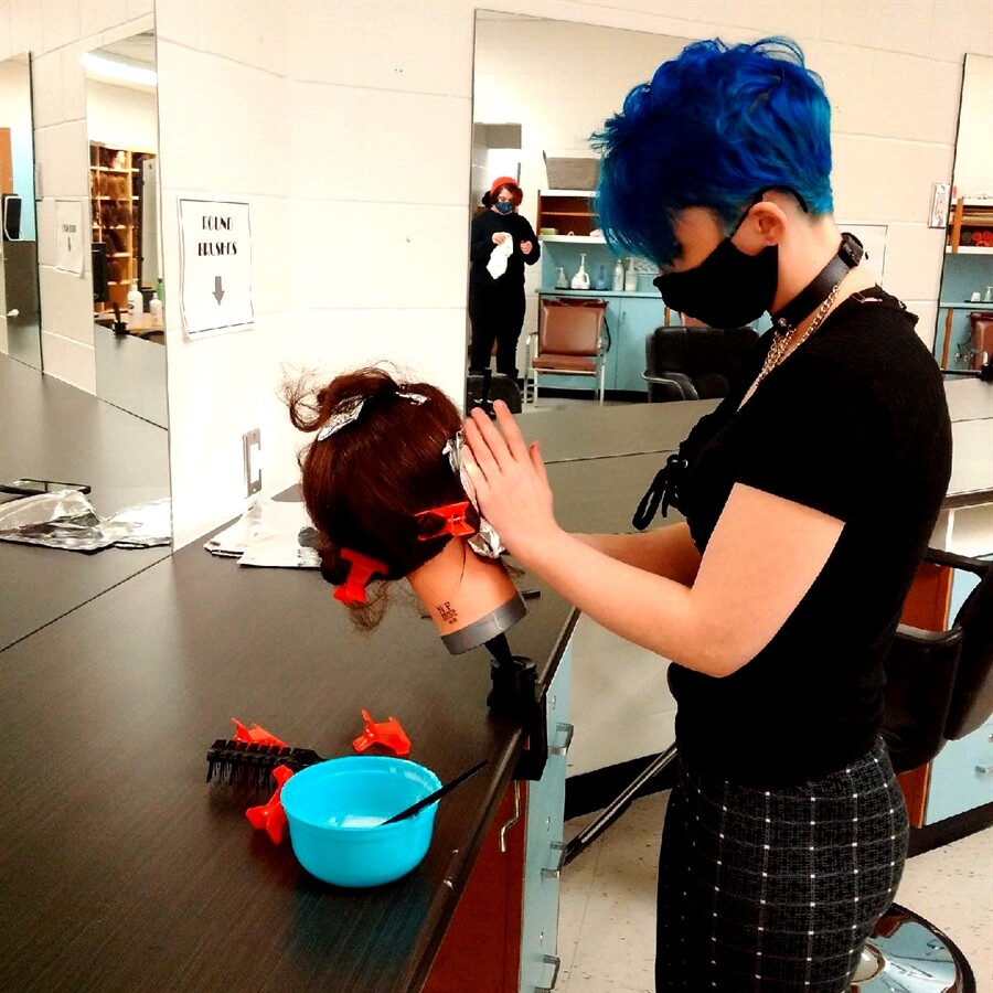 picture of a student doing a mannequin dolls hair