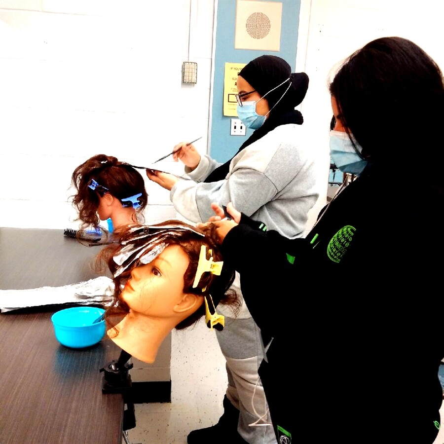 Student doing a mannequin dolls hair