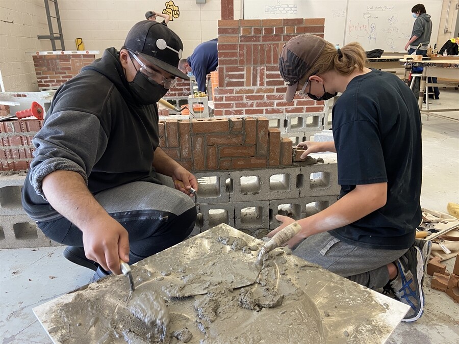 picture of students building a brick walll