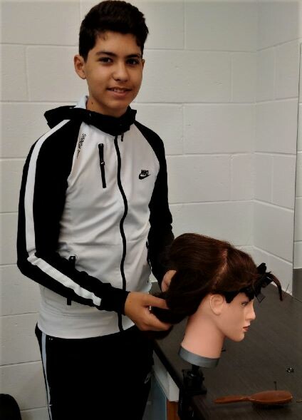 picture of a student doing a mannequin dolls hair