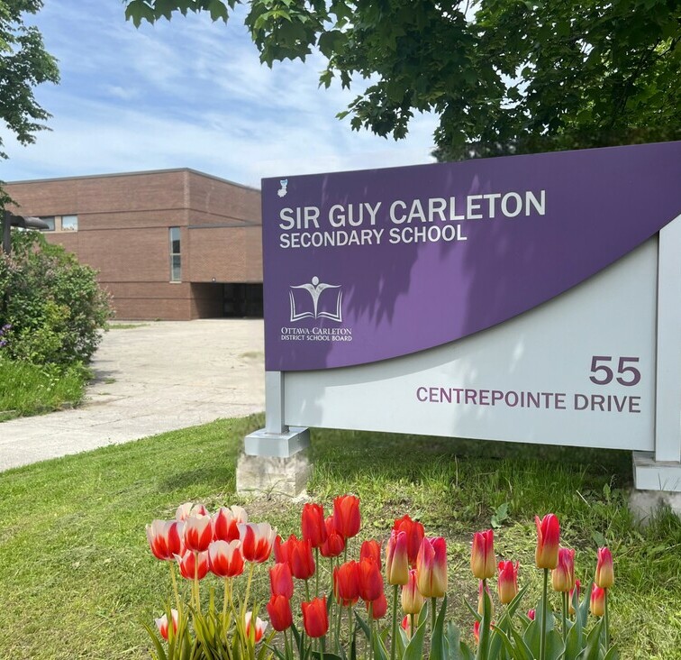 Sir Guy Carleton sign with tulips in front of it