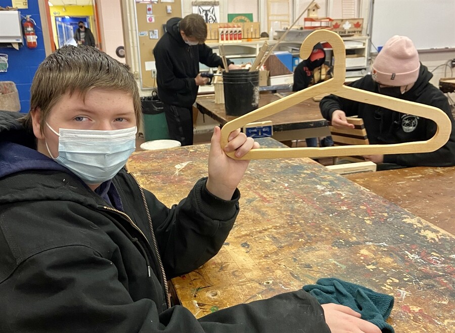 picture of a student holding a wooden hanger